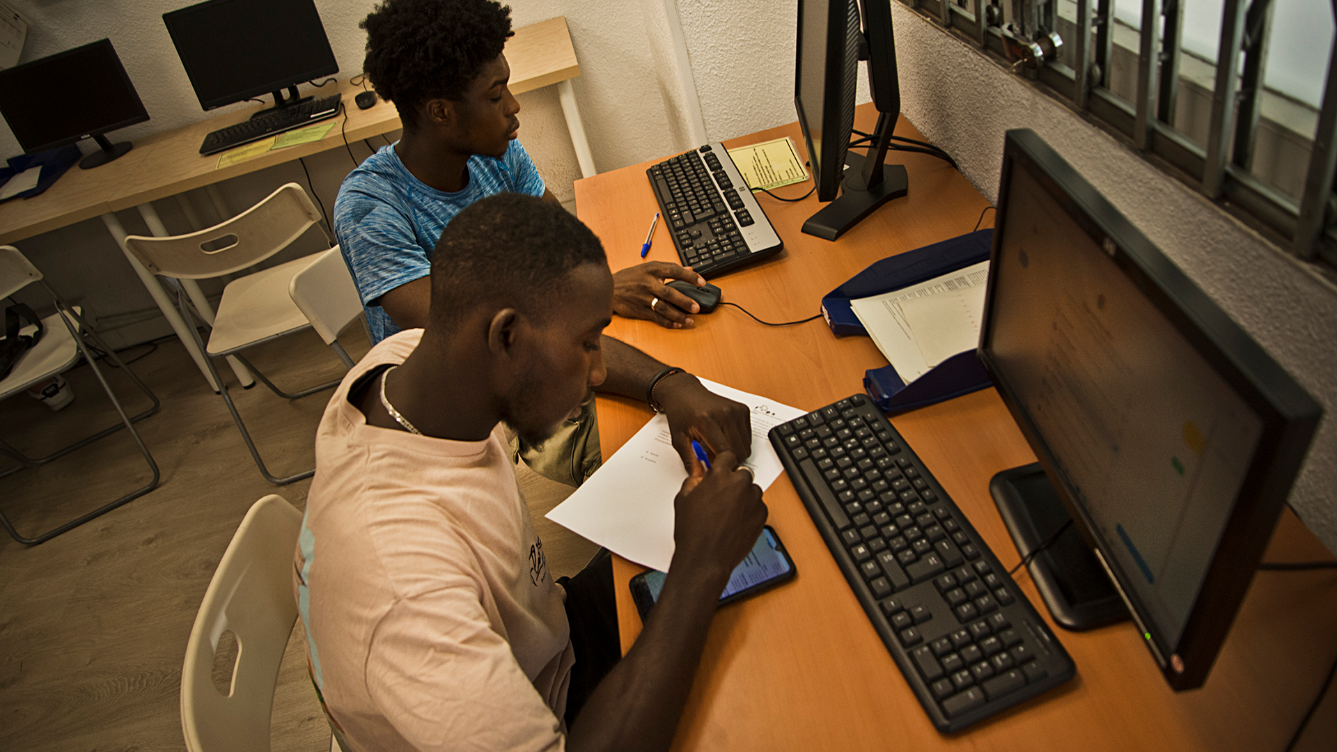 Dos jóvenes extutelados racializados en un aula de informática.