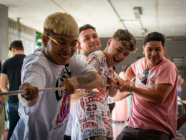 Un grupo de cuatro jóvenes tira de una cuerda de forma colabortiva.