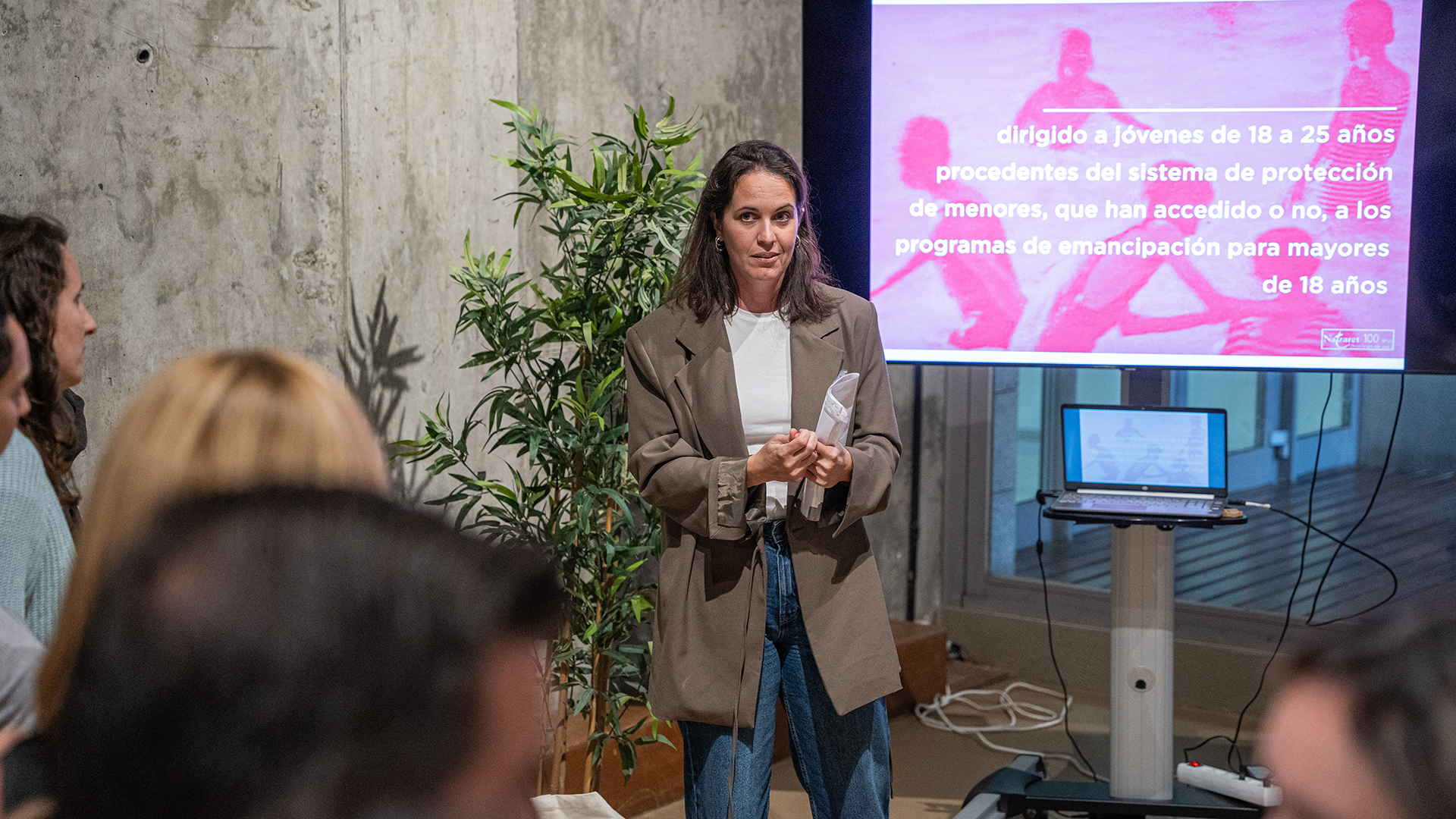 Una profesional de Fundació Natzaret expone una buena práctica apoyándose en una presentación.