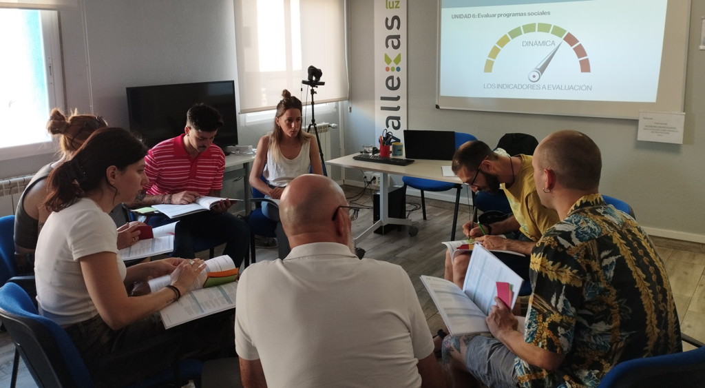 Un subgrupo de 8 profesionales debate en círculo sobre la importancia de la evaluación de programas sociales.