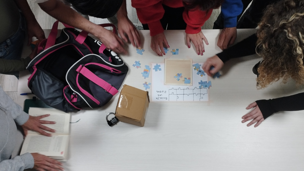Cuatro chicos alrededor de una mesa tratan de resolver una prueba de un puzzle.