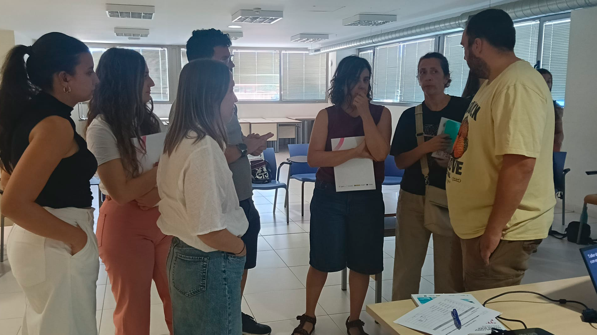 Un grupo de profesionales, de pie, hablando al cierre de la sesión del proyecto 'Un impulso hacia la emancipación' de FEPA.